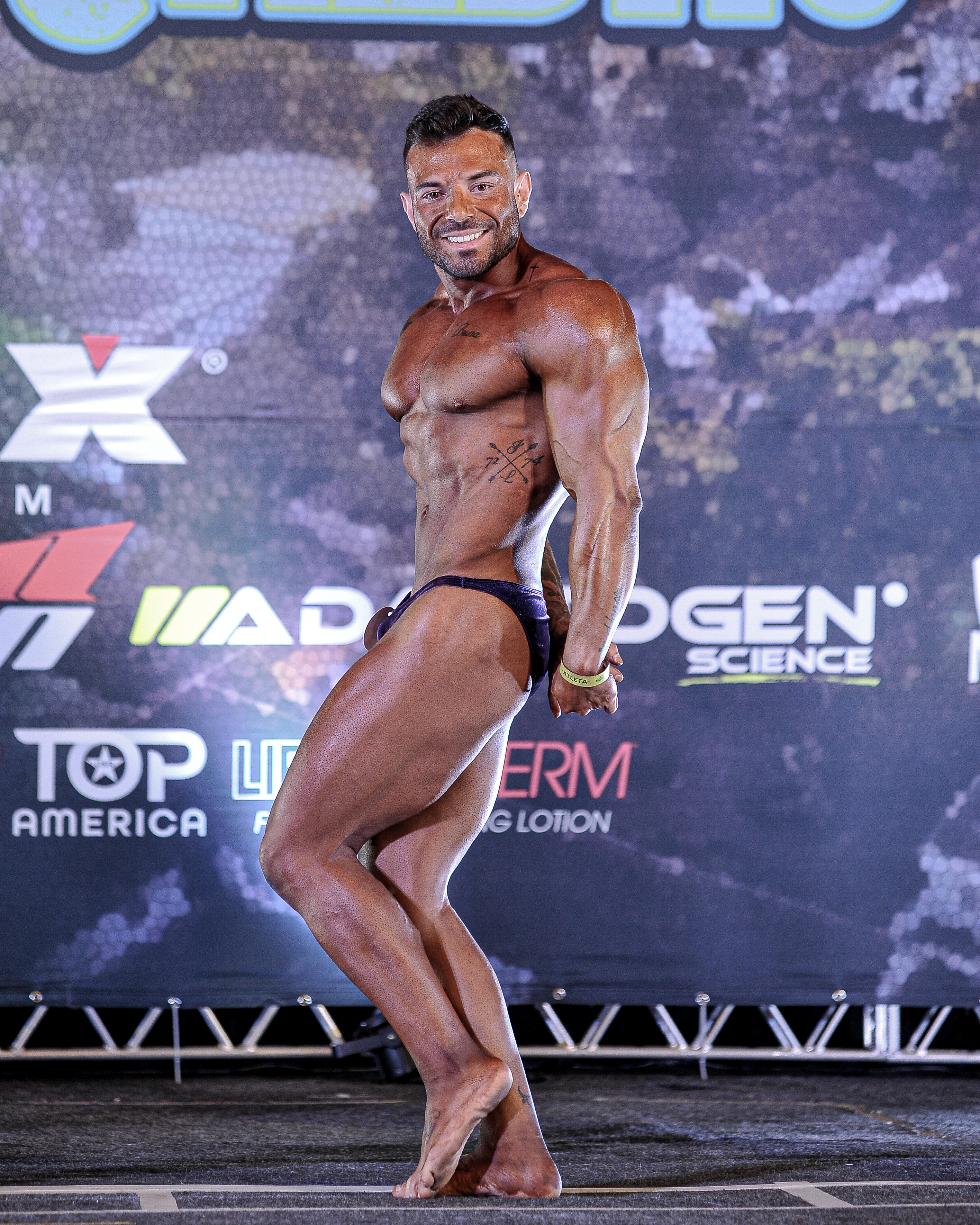 Lucas Garbulha em pose de fisiculturismo no palco
